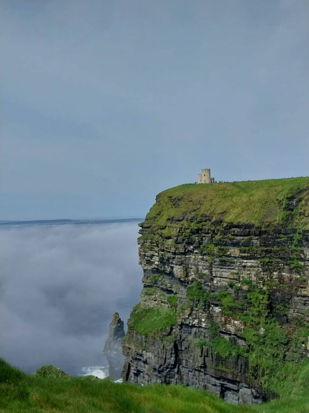 Klippen, klitschnasse Klamotten und ein Regenschirm im&nbsp;Atlantik